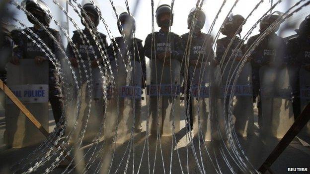 Nepalese riot police personnel stand guard in front of a barricade during a general strike in Kathmandu January 20, 2015.