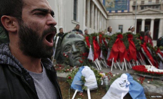 A supporter of the Greek Communist party shouts slogans in front of a monument inside the Athens Polytechnic school, on the eve of the 41st anniversary of a 1973 student uprising against the then military ruling junta in Athens, 16 November 2014.