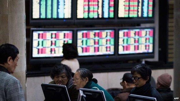 Investors look through stock information at a trading hall of a securities firm in Shanghai