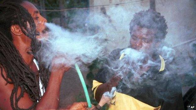 Jah P., left, and Jah Henry, smoke marijuana from a chillum pipe in Kingston, Jamaica, Wednesday, Aug. 18, 1999.