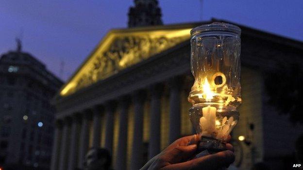 A boy holds up a candle during a demo at Plaza de Mayo square in Buenos Aires on 19 January, 2015