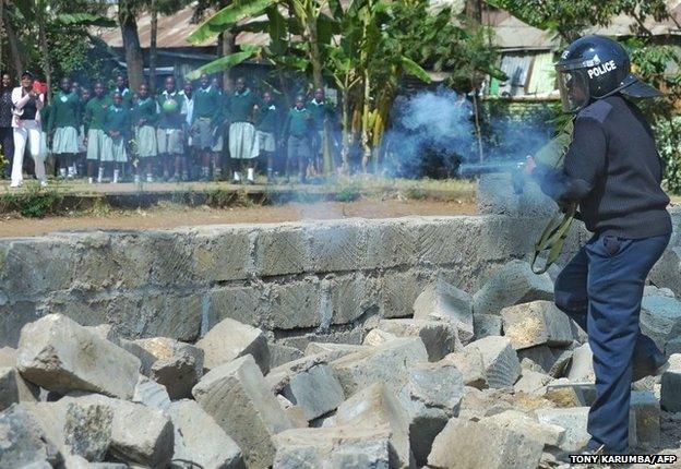 A policeman fires teargas