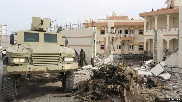 Armoured vehicle parked next to the wreck of a car that exploded outside the SYL Hotel in Mogadishu, Somalia - 22 January 2015