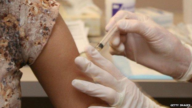 A young woman gets a measles vaccination shot.