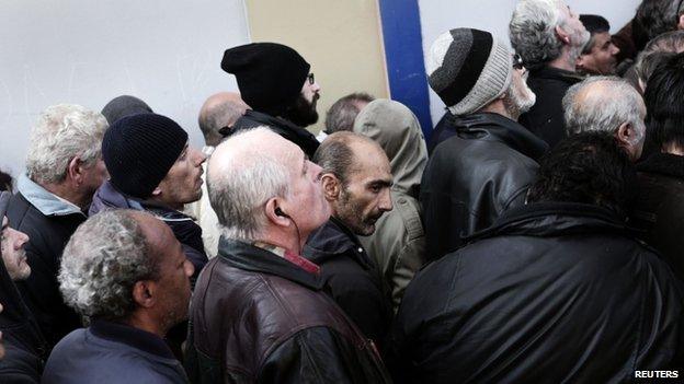 People wait to enter an indoor gym hall for a Christmas meal for the homeless and the poor in Athens, 25 December 2014