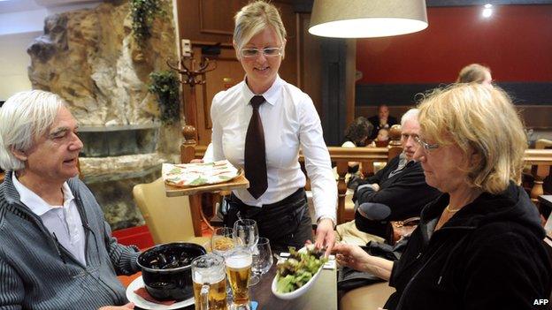 Waitress serves customers in French restaurant