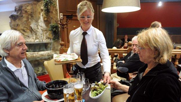 Waitress serves customers in French restaurant