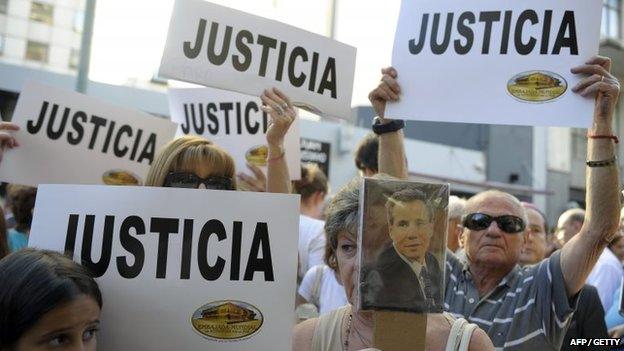 People hold placards that read "Justice" during a rally in front of the headquarters of the AMIA (Argentine Israelite Mutual Association), in Buenos Aires on 21 January 2015