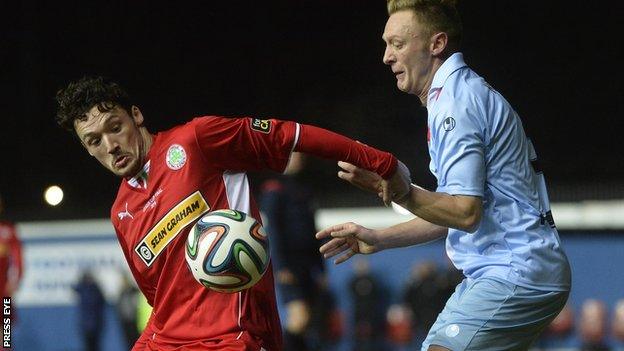 Cliftonville midfielder Tomas Cosgrove shields the ball from Ballymena's Stephen McBride