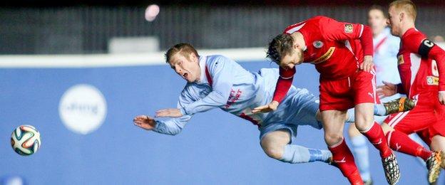 Ballymena forward Darren Boyce and Cliftonville defender Marc Smyth go head first for the ball