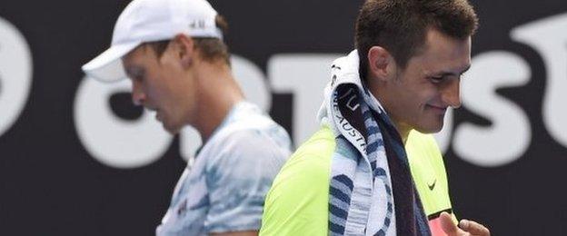 Bernard Tomic of Australia, right, walks past Tomas Berdych