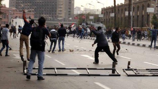 Anti-government protesters throw stones at pro-government protesters and police vehicles as police arrives to prevent anti-government protesters from entering Tahrir square in Cairo January 25, 2015.