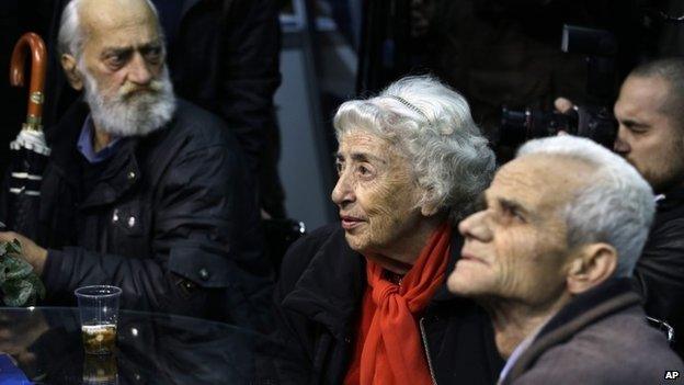 Elderly supporters of Conservative Prime Minister Antonis Samaras watch the exit poll results at the election kiosk of New Democracy party in Athens, Sunday, Jan. 25, 2015