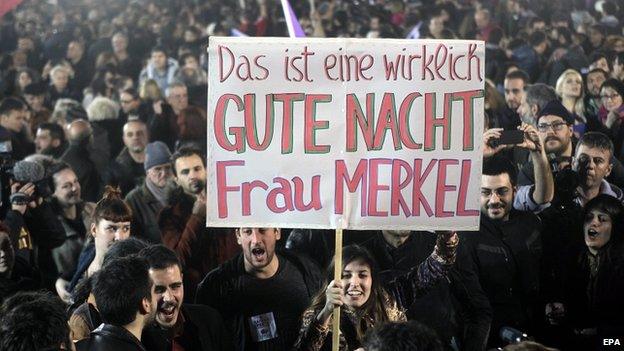 A poster held by Syriza supporters reads, "This is a really good night, Mrs Merkel"