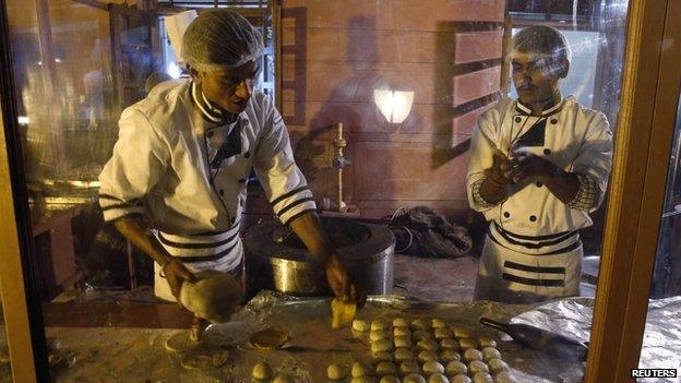 Chefs fry Indian flat bread in an outdoor kitchen surrounded by glass during an official State Dinner for U.S. President Barack Obama at the Rashtrapati Bhavan presidential palace in New Delhi January 25, 2015.