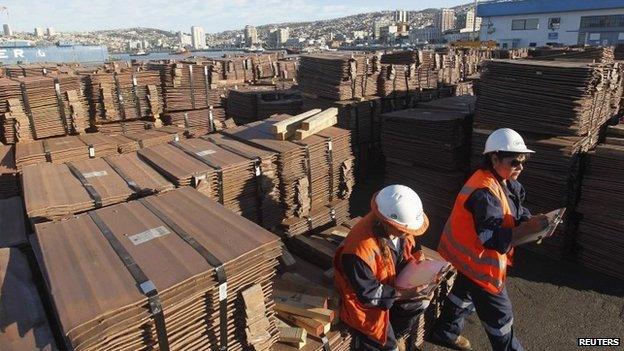 Port workers check a copper shipment that is to be exported to Asia, in Valparaiso port, northwest of Santiago on 25 January, 2015.