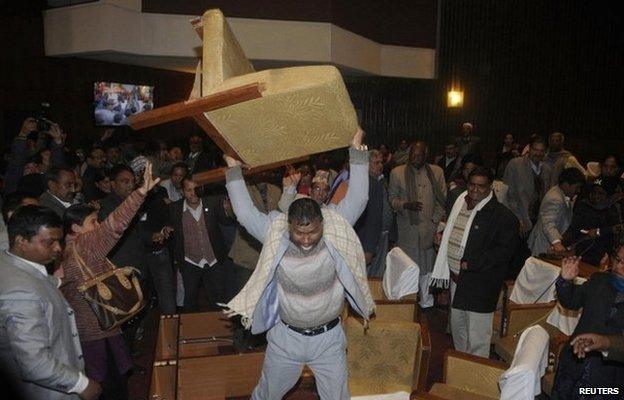 A constitution assembly member of an opposition party throws a chair during a meeting inside the Constitution Assembly building in Kathmandu January 20, 2015.