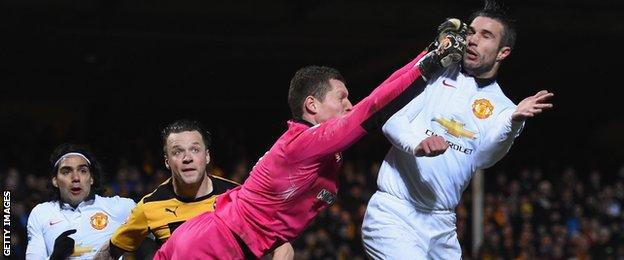 Robin Van Persie is hit in the face by Cambridge goalkeeper Chris Dunn