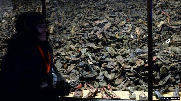 A visitor walks past prisoners' shoes on display at the memorial site of the former Auschwitz concentration camp