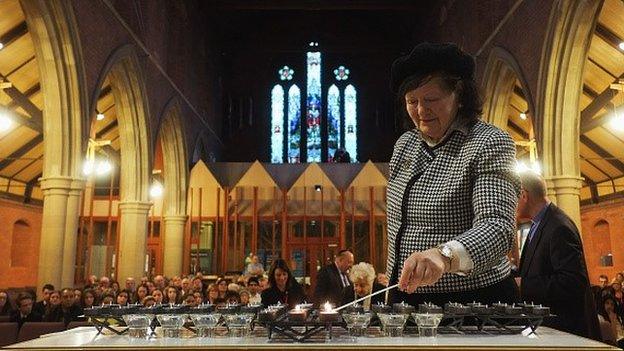 Gwen Lamb lights a candle during a Holocaust Memorial Day Service at St Barnabas Church in Middlesbrough