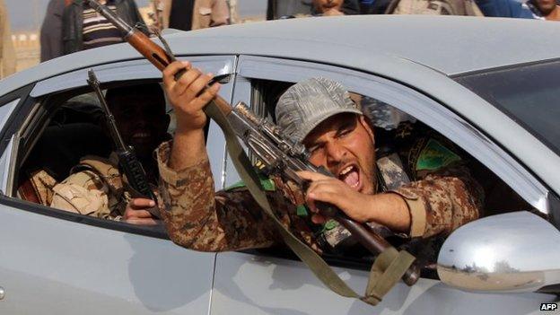 An Iraqi Shia fighter celebrates as he drives through the town of Deli Abbas in Iraq's Diyala province, northeast of Baghdad, amid claims province has been liberated from Islamic State (IS) on Tuesday