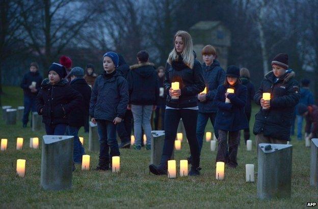 Children bring candles to the site of the Theresienstadt Nazi concentration camp in the Czech Republic, 27 January