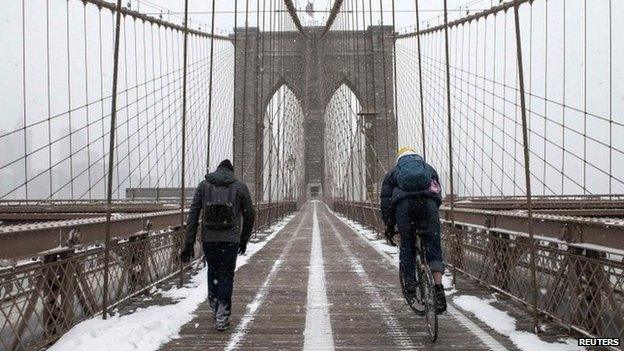 Commuters make their way across the Brooklyn Bridge after a snow storm in New York January 27, 2015.