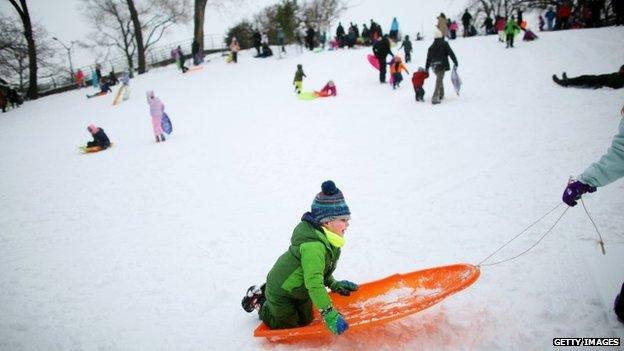 Allen Minard, 4, from Manhattan, is pulled back up after sledding down a hill on January 27, 2015 in Carl Schurz Park in New York.