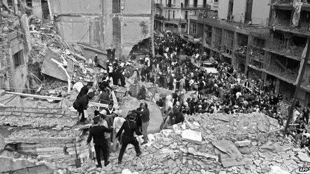 Firemen and policemen search for wounded people after a bomb exploded at the Argentinean Israelite Mutual Association (AMIA) in Buenos Aires