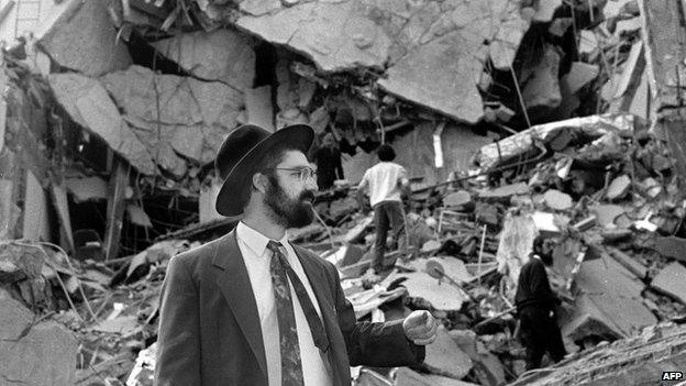 A man walks over the rubble left after a bomb exploded at the Amia centre in Buenos Aires on 18 July 1994