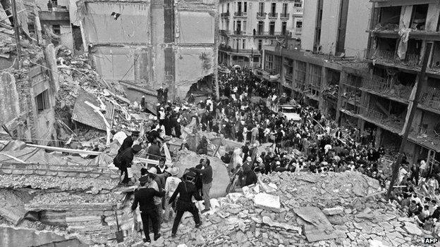 Firemen, policemen and rescuers search as wounded people after a bomb exploded at the Amia centre in Buenos Aires on 18 July 199