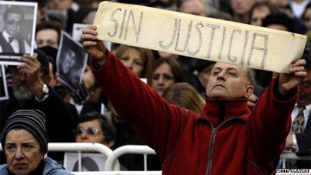 A man shows a placard that reads 'Without Justice' a during a commemoration on July 18, 2012, of the Amia attack.