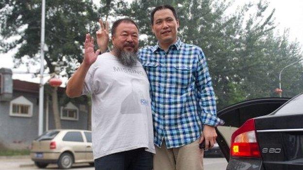 Chinese artist Ai Weiwei (L) stands with his lawyer Pu Zhiqiang as he leaves for court in Beijing on July 20, 2012.