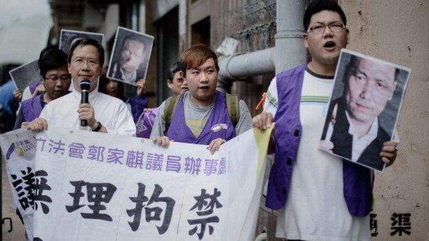 Protesters holding pictures of Chinese human rights lawyer Pu Zhiqiang march to the Chinese liaison office in Hong Kong on May 14, 2014 asking for his release following his arrest in Beijing.