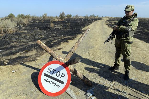 A Ukrainian serviceman stands guard at a Ukrainian National Guard position on the border checkpoint near Novoazovsk, Donetsk region, August 2014