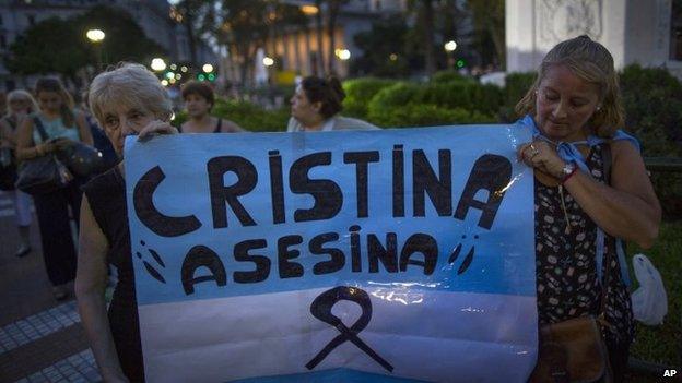 Protesters hold a sign that reads in Spanish "Cristina Assassin" in Buenos Aires on 26 January, 2015