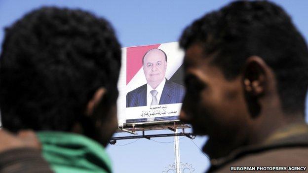 Yemeni men under a banner showing former Yemeni President Abd Rabu Mansour Hadi in Sana'a, Yemen, on 23 January 2015