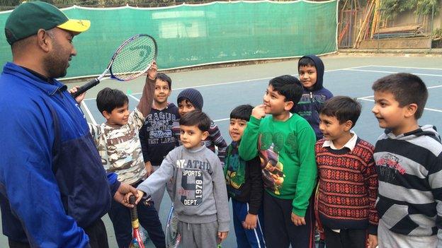 Children listening to their tennis coach