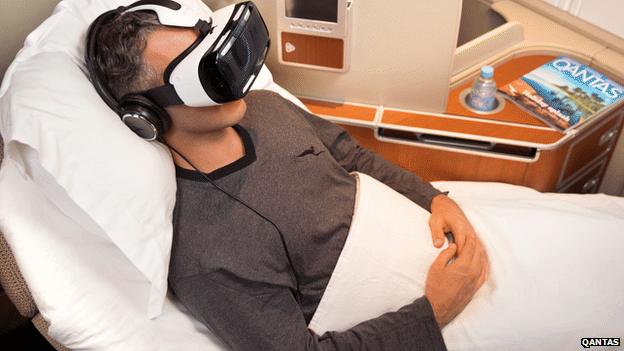 Man on plane wearing Samsung Gear virtual reality headset