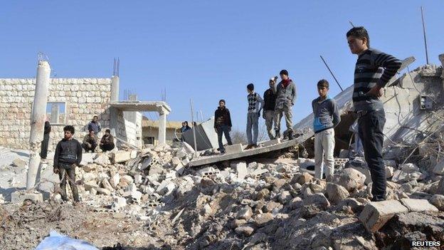 Residents inspect a site damaged by what activists said were barrel bombs thrown by warplanes loyal to Syria"s President Bashar Al-Assad in Kansaghra village, Jabal al-Zawiya in the southern countryside of Idlib 25 January 2015.