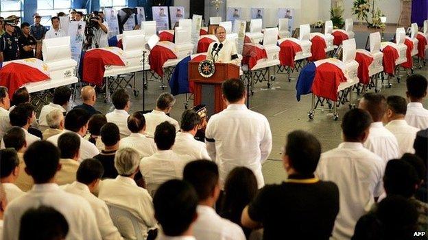 Philippine President Benigno Aquino gives a message in front of the coffins of police commandos killed in a botched anti-terror operation during a necrological service at the Camp Bagong Diwa, in Manila on January 30, 2015.