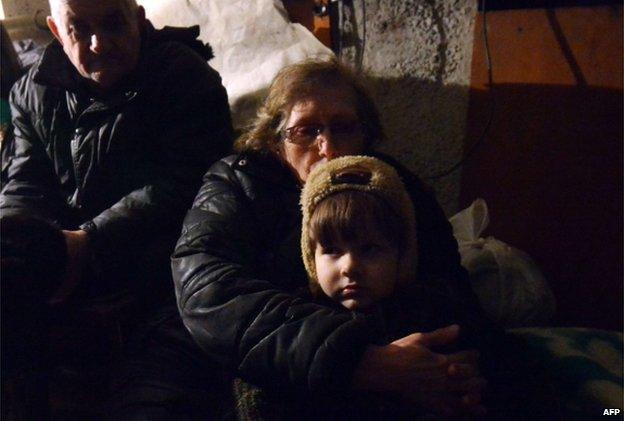 People wait in a shelter for the end of a shelling in Enakieve, south-western Debaltseve on 29 January 2015