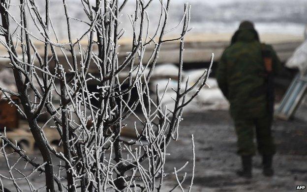 A pro-Russian separatist soldiers stand guard at a checkpoint in Enakieve, 25km south-west of Debaltseve, on 29 January 2015