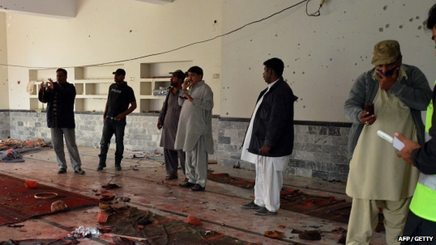 Pakistani security officials gather at a mosque after a bomb explosion in Shikarpur in Sindh province,