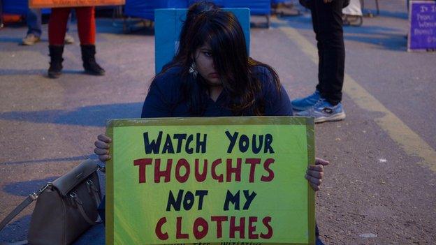 A woman holds up a feminist sign.