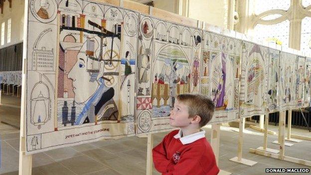 Boy standing in front of Great Tapestry of Scotland