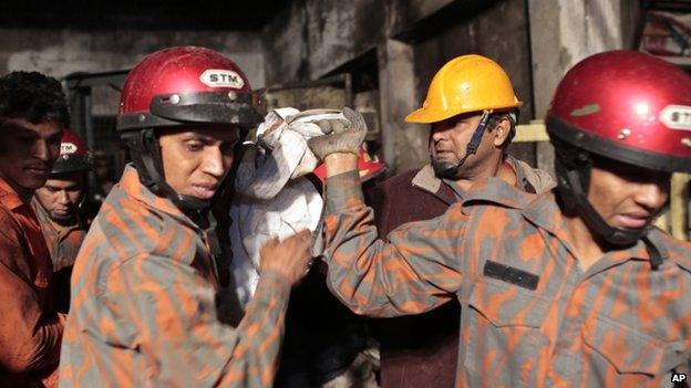 Fire-fighters carry the body of a victim of a fire in Dhaka. Photo: 31 January 2015