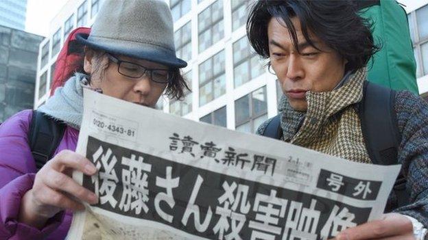 People read special edition of newspaper in Tokyo, after announcement of Kenji Goto's death