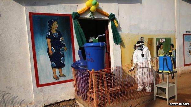 A health worker wearing protective clothing waits outside Redemption Hospital on 1 February 2015 in Monrovia, Liberia.