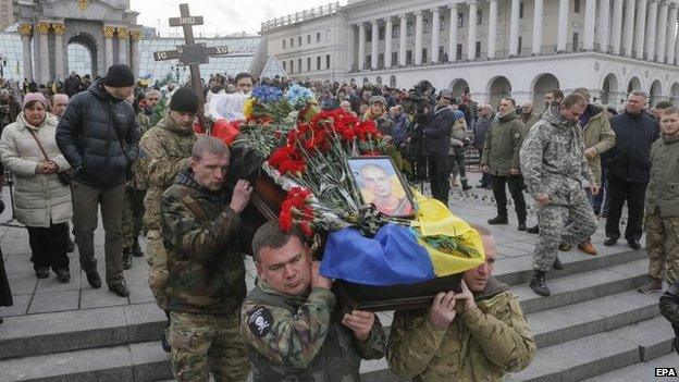 Aidar battalion volunteers carry a coffin with body of their friend, who was killed in eastern Ukraine conflict, during the funeral ceremony on the Independence Square in Kiev, Ukraine, 2 February 2015